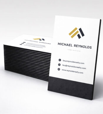A stack of black edge painted business cards with one card positioned vertically.