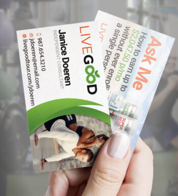 Hand holding both sides of the LiveGood business card.