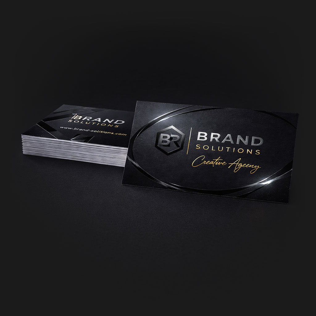 A stack of black business cards that shine only on certain areas by using the Spot UV technique where gloss is applied to a few areas instead of the whole card making logos and other parts stand out.